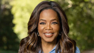 Oprah Winfrey posando para foto com árvores ao fundo 