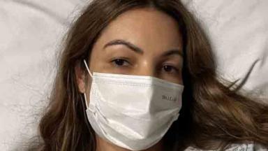 Patrícia Poeta deitada na cama de hospital e de máscara 