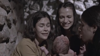 Cena da primeira temporada de Reis com três atrizes segurando e olhando para um bebê recém-nascido. E estreia dia 22 na Record 
