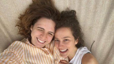 Renata Gaspar de camisa listrada abraçada a Bebel Luz, de camiseta branca, sorrindo para selfie 