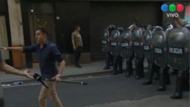 Heber Ybañez em frente à barreira policial, com microfone, caminhando 