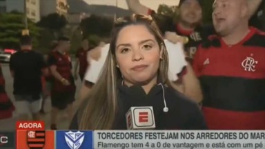 Jéssica Dias constrangida, com microfone na mão, com torcedores do Flamengo atrás dela 
