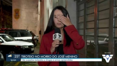Repórter da Globo segurando o microfone com a mão na cabeça 