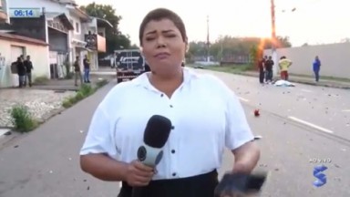 Repórter da Record Lívia Costa emocionada com microfone na mão no local de acidente 