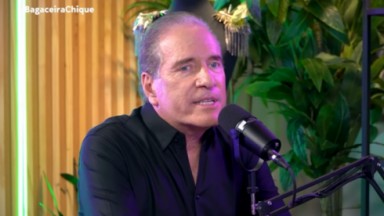 Roberto Justus falando em microfone, vestindo camisa social preta 
