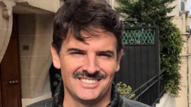 Roberto Munhoz em foto publicada no Facebook; jornalista sorri, está com bigode e cabelos cortados na região da testa 