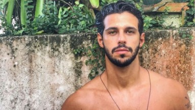 Rodrigo Mussi posado sem camisa encostado em um muro 