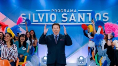 Silvio Santos no comando de seu programa no SBT. Plateia feminina ergue pom-pom  