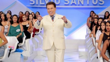 Silvio Santos de roupa bege, rindo e gesticulando 
