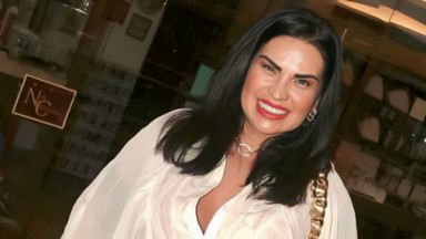 Solange Gomes sorrindo, de batom vermelho e camisa branca 