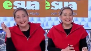  Sonia Abrão de blusa preta e colete vermelho, com cabelo preso, rindo, no cenário do A Tarde É Sua 