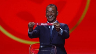 Cafú sorridente ao mostrar o nome do Brasil no papel do sorteio 