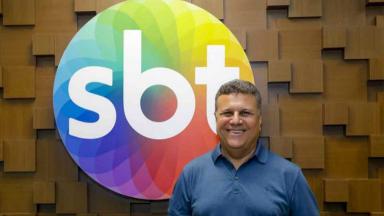 Téo José à frente do logotipo do SBT 