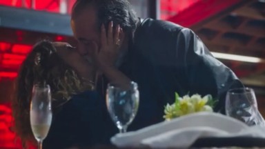 Agatha e Antônio se beijando perto de mesa cheia de taças 