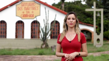  Camila Morais, reportagem da TV Aparecida, posando para foto com um vestido vermelho e posando para foto 