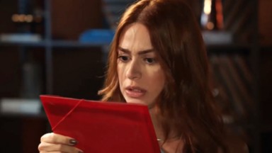 Elisa lendo documentos em cena de Família é Tudo 
