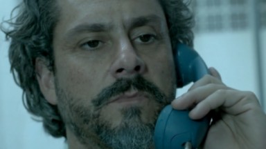 José Alfredo segurando o telefone no ouvido e expressão séria 