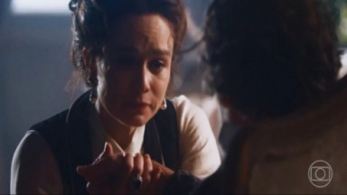 Luísa segurando a mão de Dominique em cena de Nos Tempos do Imperador 