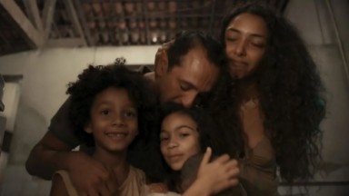 Tião Galinha abraçado à mulher e filhos em cena de Renascer 