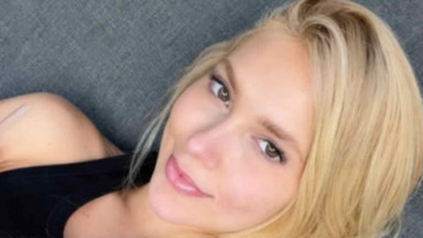 Virginia deitada em sofá cinza e sem sorrir na foto de Stories 