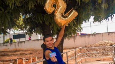 Marcos Vinicius, o Vyni do BBB22, exibe cartão de vacina e segura um balão com o número 2. Foto foi postada no Instagram para comemorar 2 milhões de seguidores 
