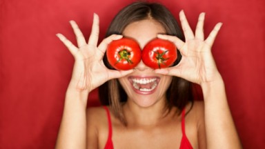 Mulher sorrindo com tomate nos olhos 