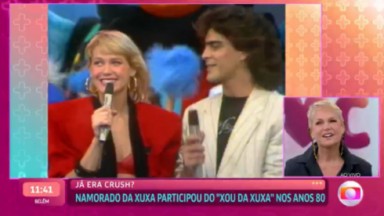 Xuxa vendo vídeo antigo dela entrevistando Junno Andrade e sorrindo 
