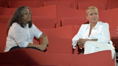 Marlene Mattos e Xuxa sentadas em um teatro 