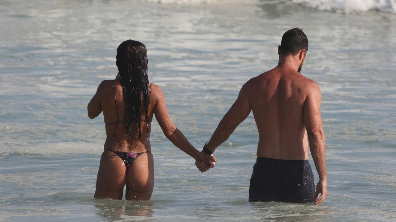 Ostentando corpão, Juliana Paes beija muito em praia do Rio