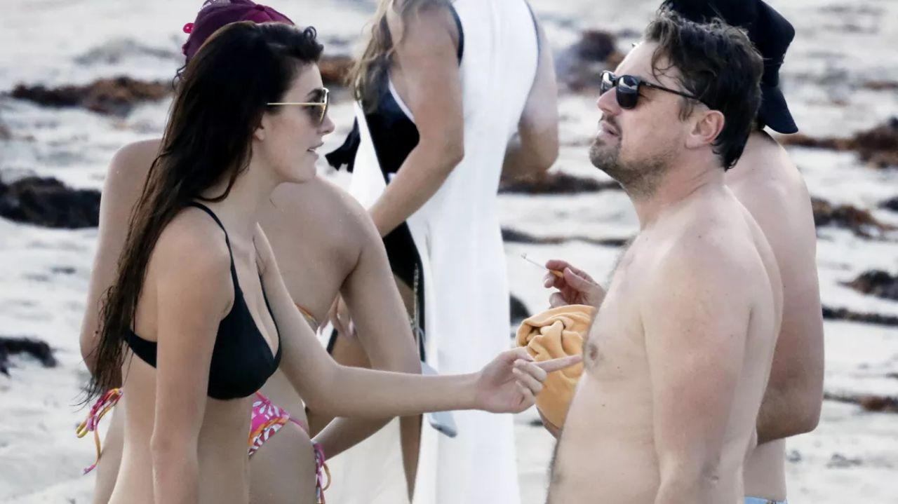 Camila Morrone e Leonardo DiCaprio em pé na praia