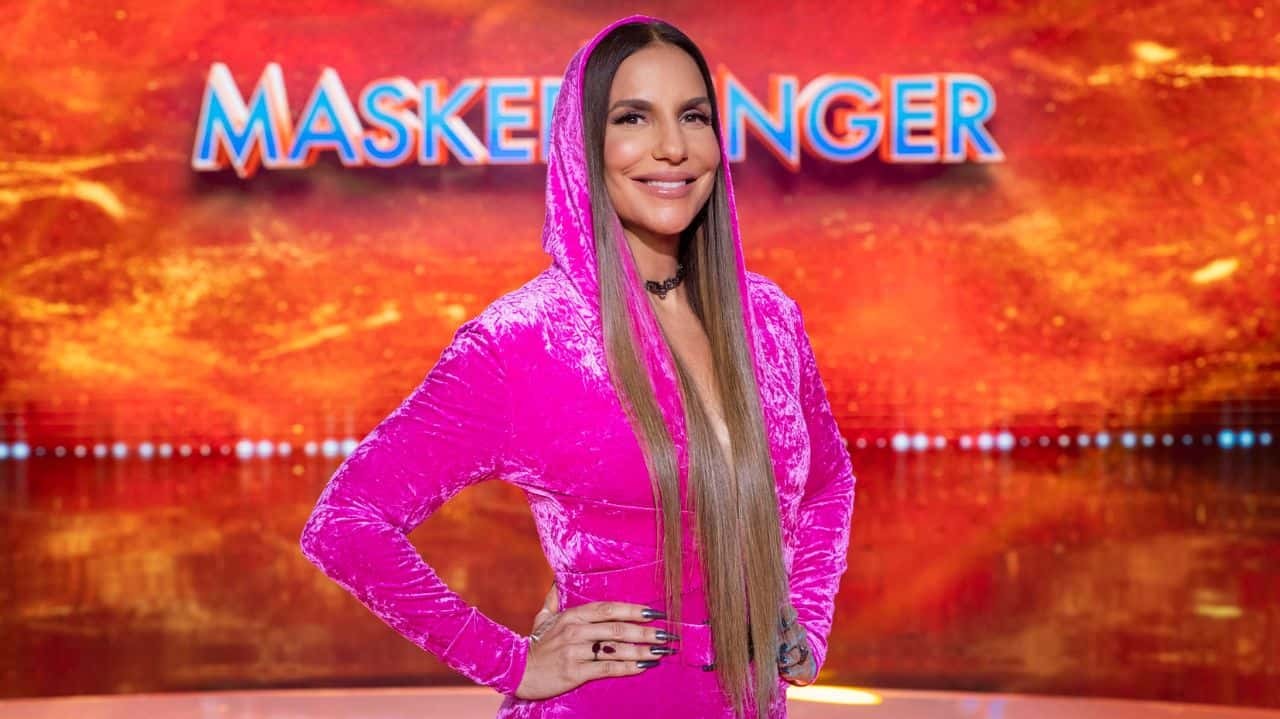 Ivete Sangalo de roupa rosa sorrindo no palco do The Masked Singer Brasil