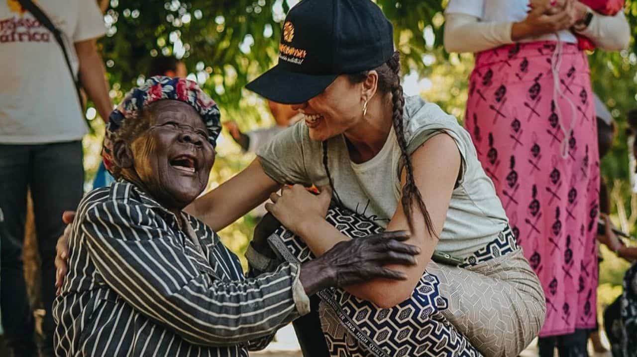 Rafa Kalimann sorrindo com idosa na África