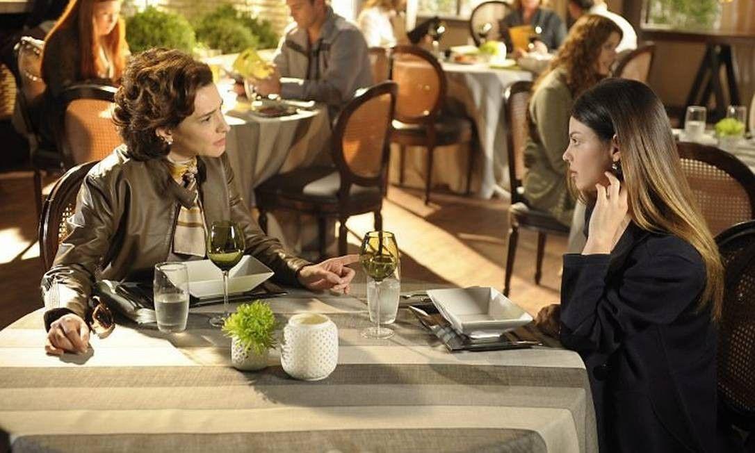 Vitória e Alice sentadas de frente uma para outra em restaurante 