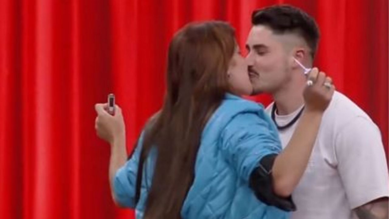 Jaquelline e Lucas se beijando em fundo vermelho