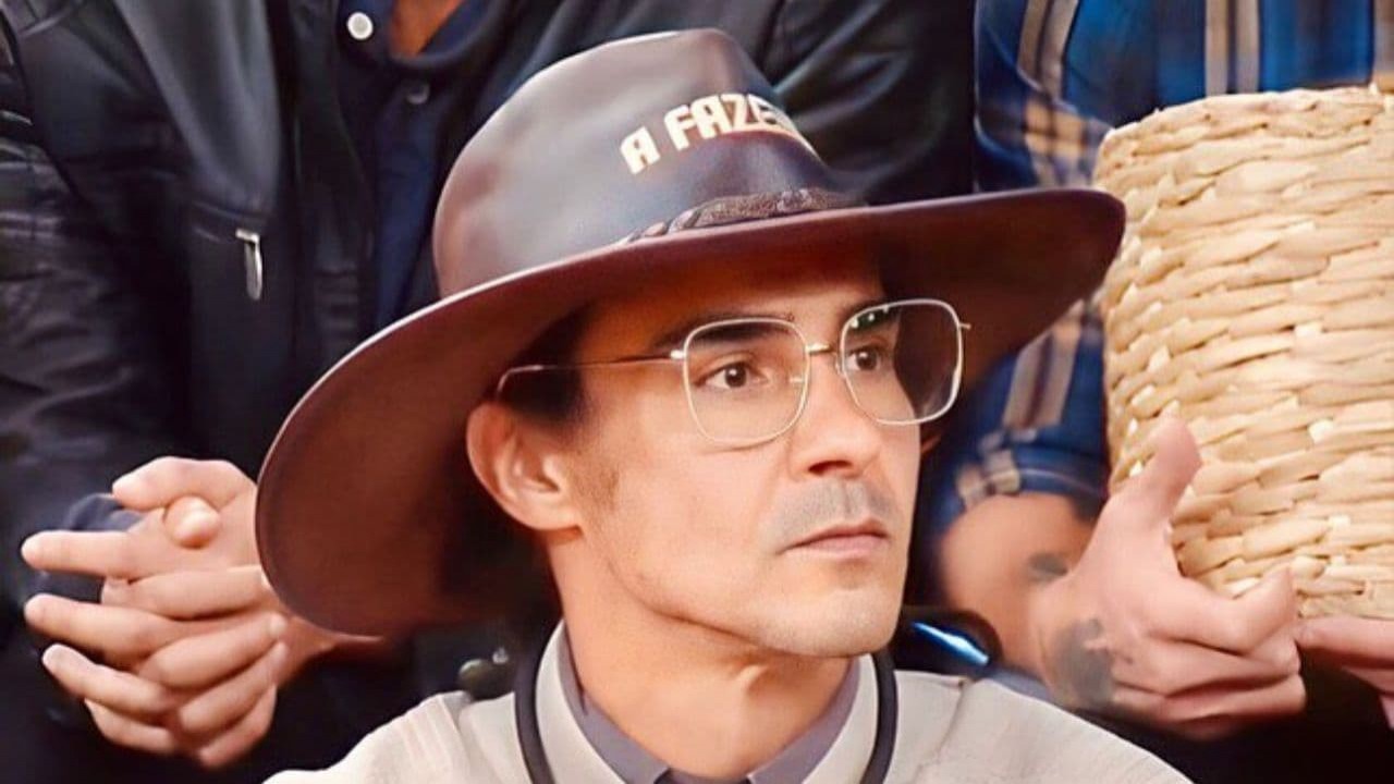 André Gonçalves de óculos e com chapéu do fazendeiro, olhando para o lado