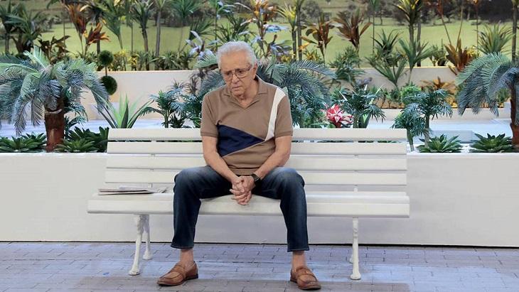 Carlos Alberto de Nóbrega sentado no banco de A Praça é Nossa