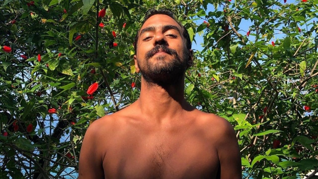 Alexandre Mortágua perto de árvore posando para foto sem camisa