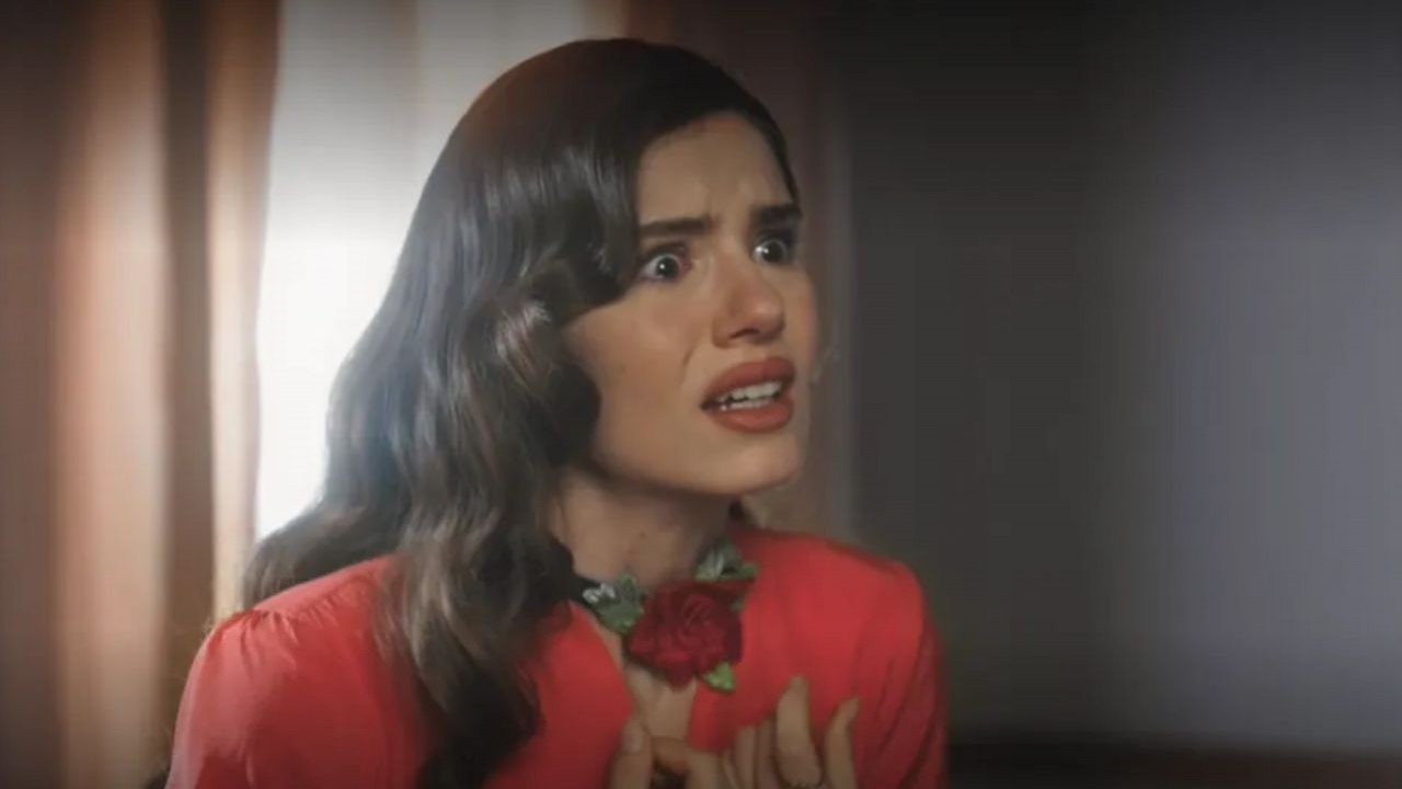 Camila Queiroz de roupa vermelha e cabelo solto, falando com expressão assustada em cena de Amor Perfeito