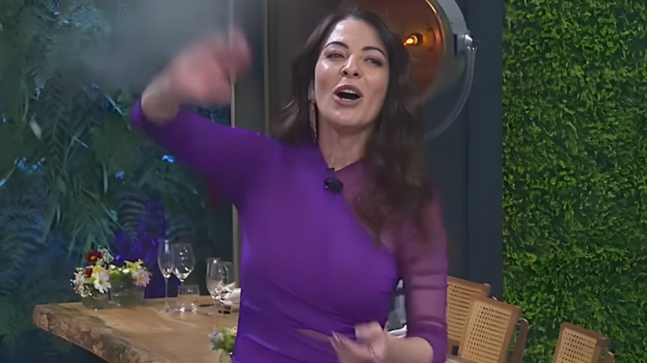 Ana Paula Padrão dando tchauzinho de camisa roxa