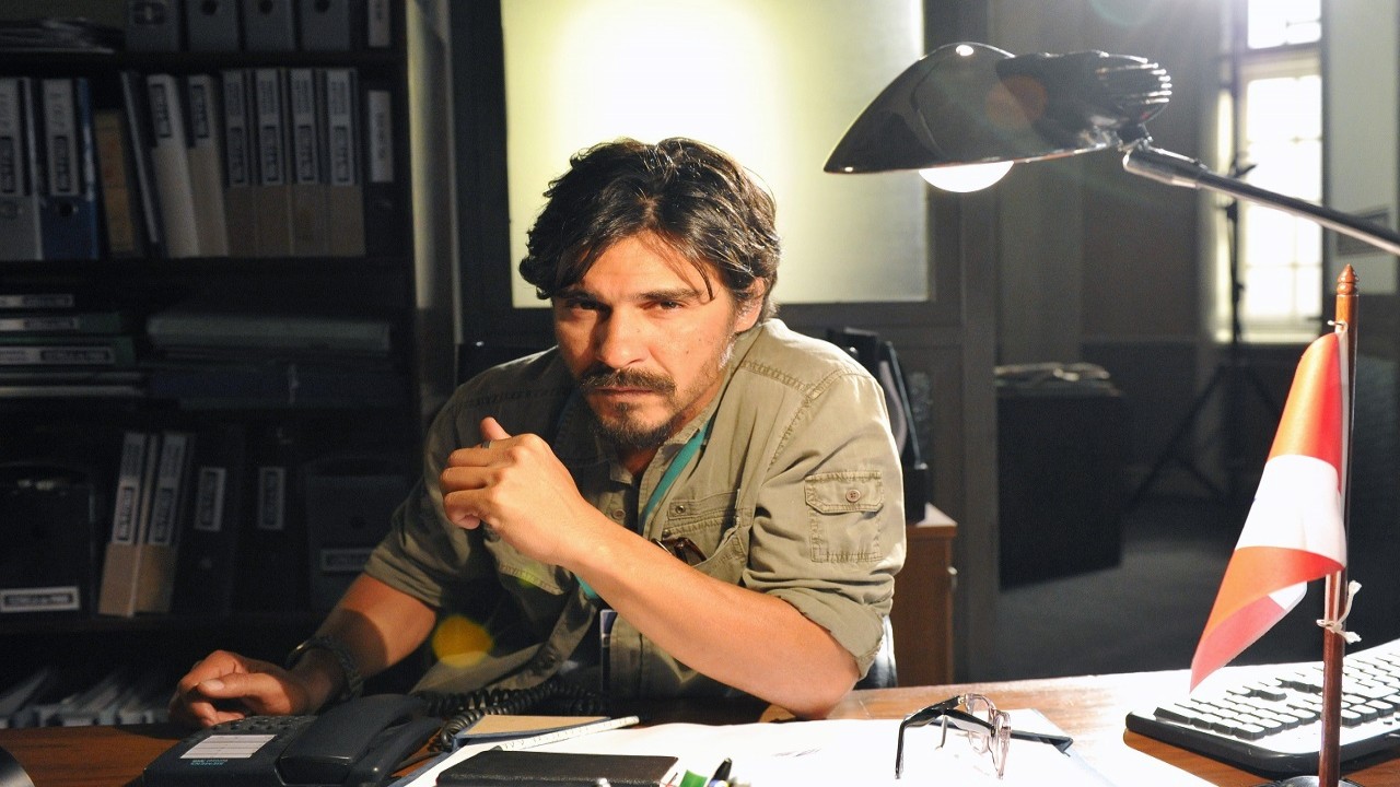 André Gonçalves sentado em uma cadeira com a mão apoiada em uma mesa