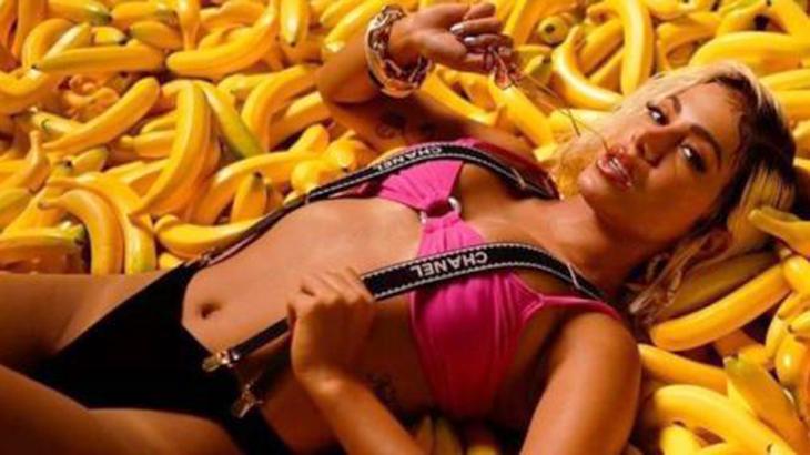 Anitta deitada em cima de bananas