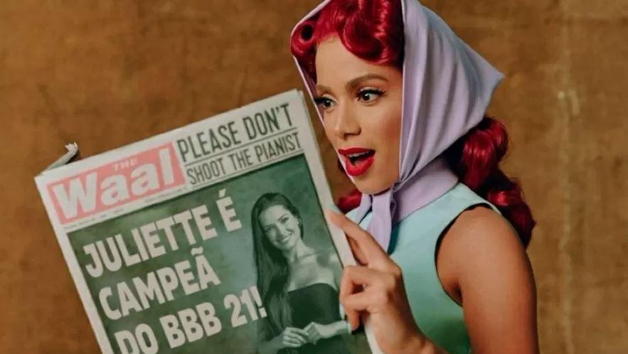 Anitta segura jornal com a manchete Juliette campeã