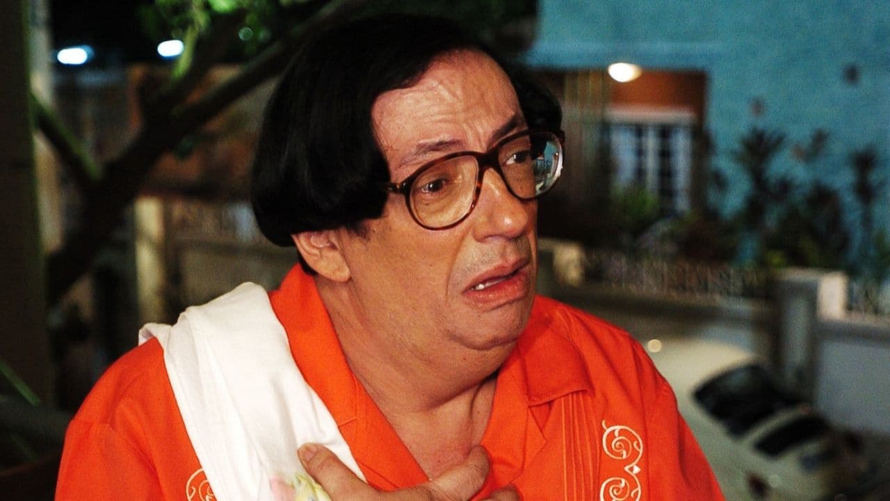 Marcos Oliveira caracterizado como Beiçola com expressão de tristeza e com roupa laranja