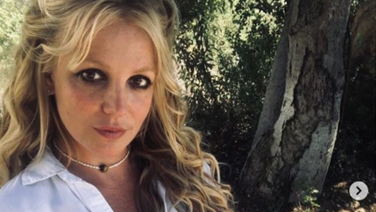 Britney Spears posada próxima a uma árvore