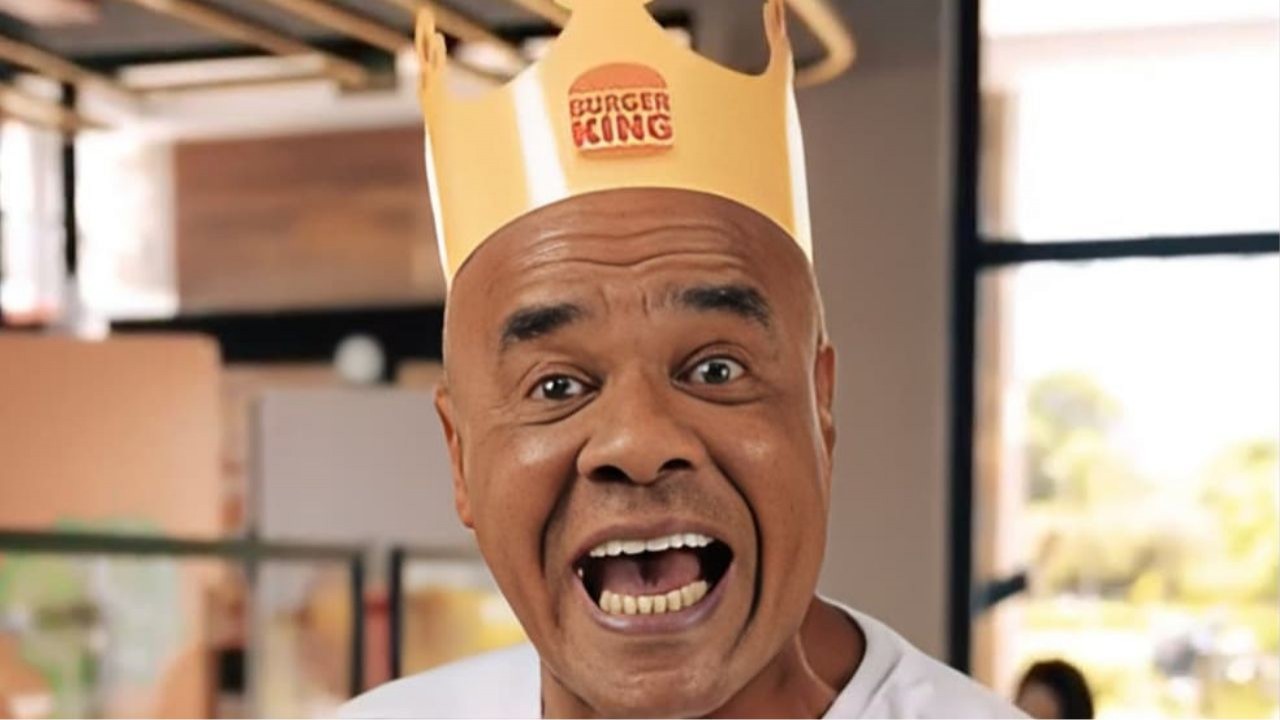 Kid Bengala com coroa do Burger King e camiseta branca, falando para a câmera