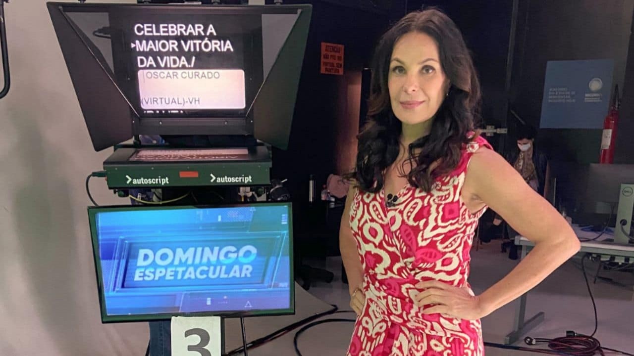 Carolina Ferraz com asmãos na cintura, posando para foto perto de câmera do Domingo Espetacular