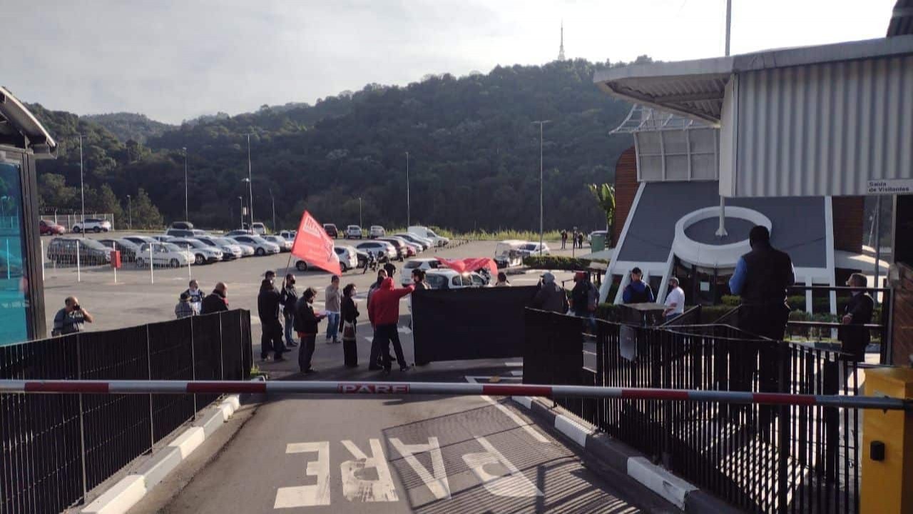 Membros do Sindicato dos Radialistas barrando a entrada da emissora e portando bandeiras