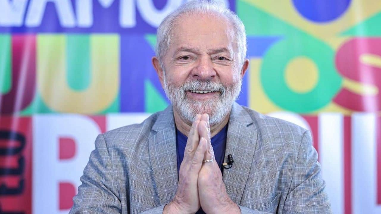 Lula sorrindo e fazendo sinal de agradecimento com as mãos