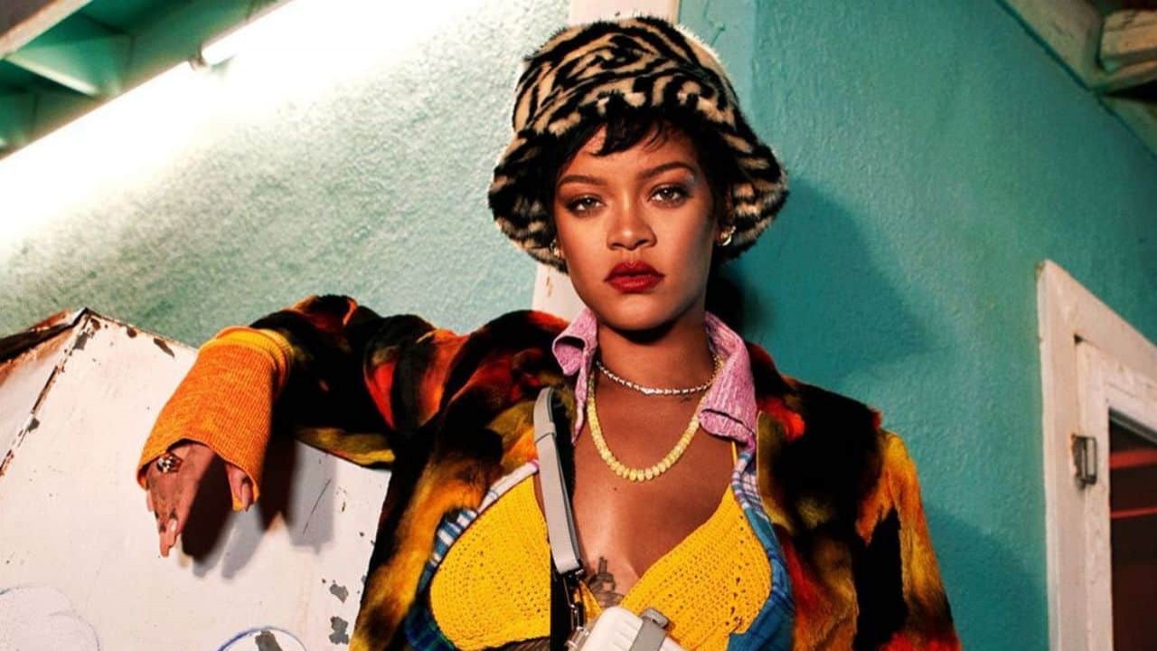 Rihanna de roupa colorida e chapéu, posando sem sorrir