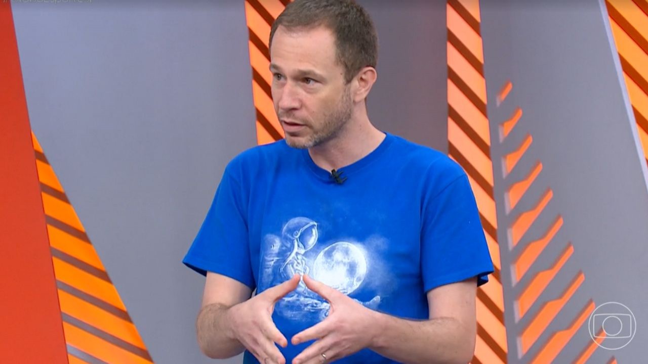 Tiago Leifert de camisa azul falando e gesticulando no Globo Esporte